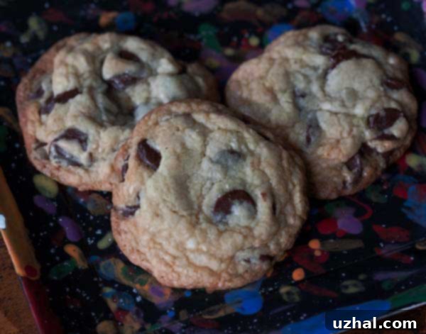 golden brown and perfectly chewy chocolate chip cookies stacked on a plate