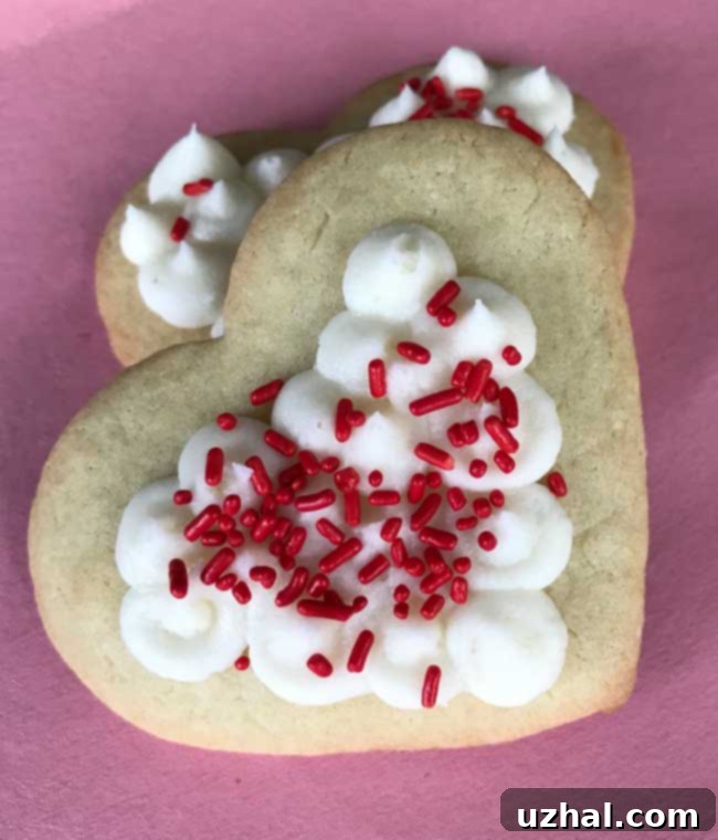 Heart-shaped sugar cookies with pristine white icing, a classic 'no-fail' recipe from Cookie Madness for easy decorating.