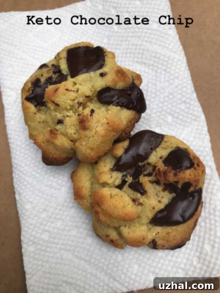 A small batch of unbaked keto chocolate chip cookie dough balls on a baking sheet, ready for the oven.