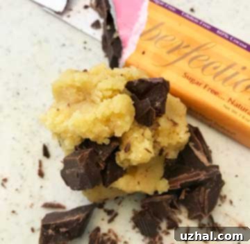 A bowl of keto chocolate chip cookie dough with visible sugar-free chocolate chips mixed in.