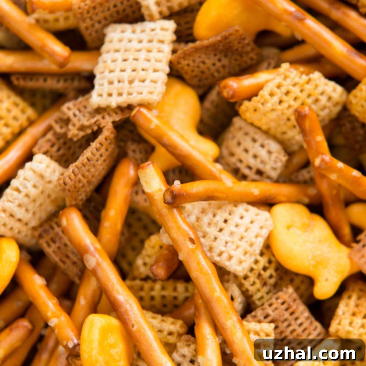 A large bowl of golden brown, savory Basic Baked Chex Mix, with various cereals, pretzels, and nuts visible, ready to be enjoyed as a classic snack.