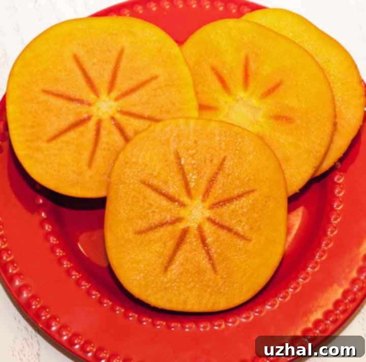 Whole and sliced ripe Fuyu persimmons, showcasing their beautiful orange color and firm flesh.