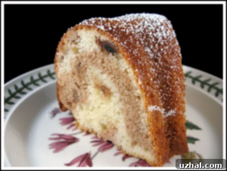 A perfectly baked slice of Walnut Marble Spice Cake with distinct layers of light and dark batter, revealing a moist and tender crumb texture.
