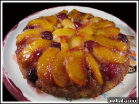A beautifully inverted peach and cherry upside down cake, with caramelized fruit topping glistening