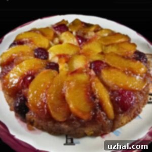 Close-up of a slice of Peach Cherry Upside Down Cake with its juicy fruit topping.