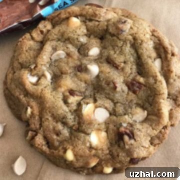 Two freshly baked Sea Salt Caramel Pecan Cookies on a white surface.