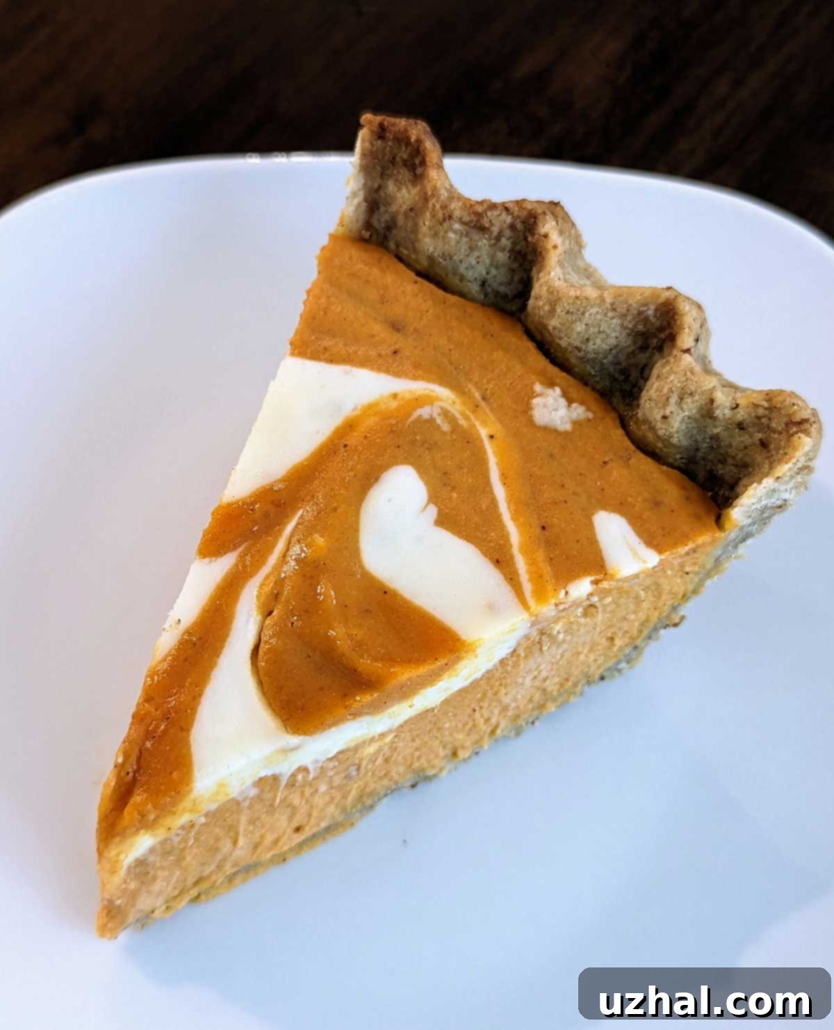 A beautifully baked Marbled Cream Cheese Pumpkin Pie with a classic, golden pastry crust, perfectly set and ready for slicing.