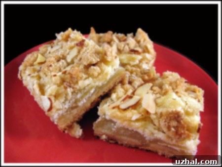Delicious Apple Almond Cheesecake Bars stacked on a plate, showcasing the creamy filling and crumbly topping.