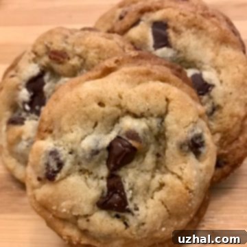 A plate of freshly baked, golden-brown Original Toll House Chocolate Chip Cookies, emphasizing the unique texture achieved with shortening