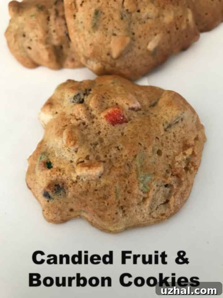 Golden-brown fruitcake cookies studded with colorful candied fruits and nuts on a cooling rack.