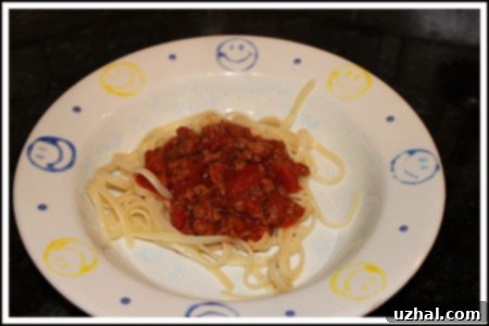 Rich homemade spaghetti sauce in a Dutch oven with fresh basil garnish