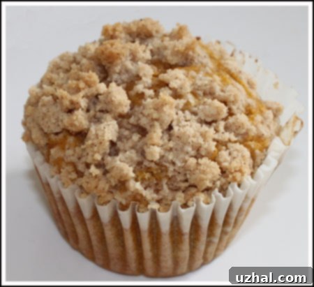Close-up of a delicious jumbo pumpkin streusel muffin, showcasing its moist interior and crumbly topping