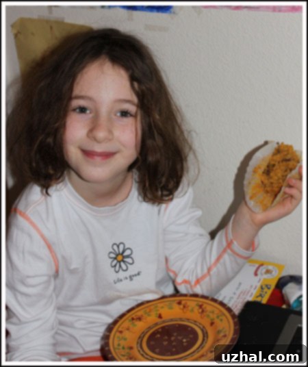 A little girl, Fuzz, happily holding a freshly baked pumpkin streusel muffin, years ago.