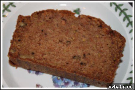 A delectable slice of moist Zucchini Apple Bread, revealing its rich texture and a hint of fresh fruit.