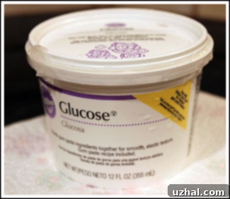 A container of glucose syrup, often found in baking or craft store aisles.