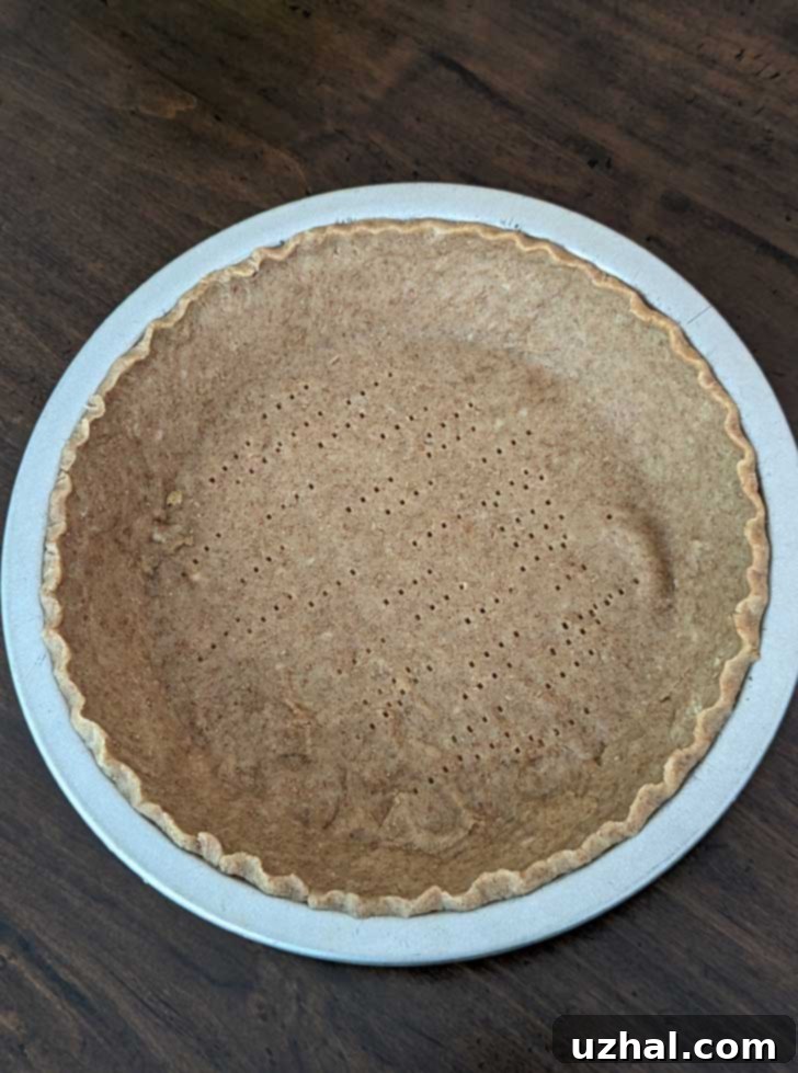 Unbaked rolled graham cracker pie shell, perfectly shaped and ready for baking.