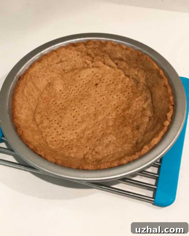 The rolled graham cracker dough in a pie dish, ready for chilling.