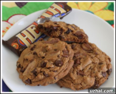 Several chocolate heath bar cookies stacked on a plate