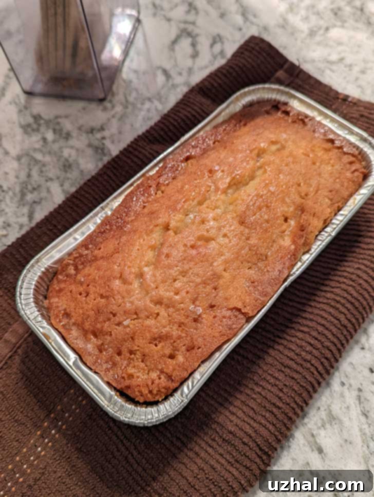 Baked Coconut Rum Pound Cake in an 8x4 inch disposable foil pan from Dollar Tree, showing its golden crust.