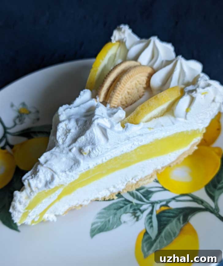 A slice of Lemon Oreo Cookies and Cream Pie on a plate, showing the distinct layers.