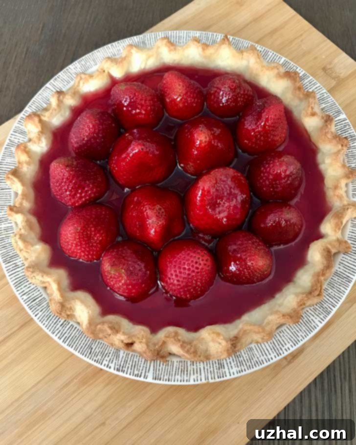 A vibrant gluten-free strawberry pie, with a golden crust and glistening red strawberry filling, ready to be served.