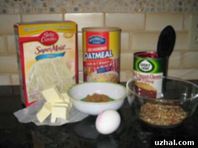Various ingredients laid out for Cherry Dream Bars, including a box of cake mix, oats, butter, an egg, and a can of cherry pie filling.