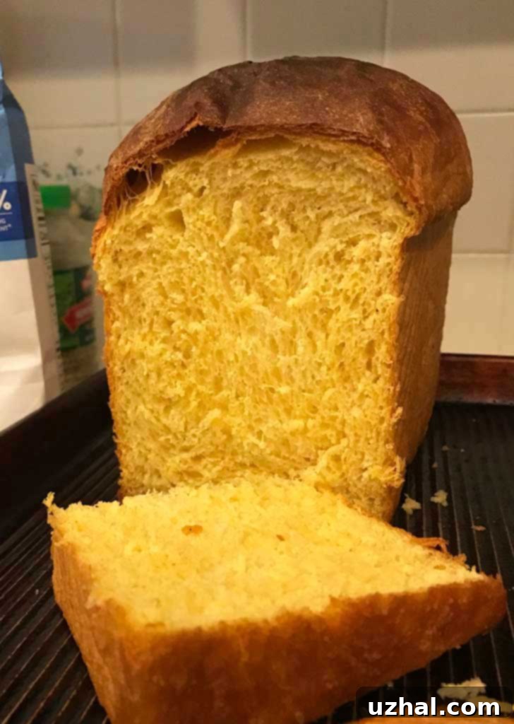 A tall, golden loaf of Sweet Potato Yeast Bread, freshly baked from a Pullman Pan, showcasing an impressive rise.