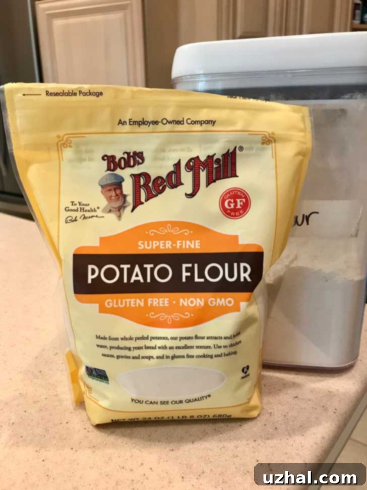 A bag of Bob's Red Mill Potato Flour next to a mixing bowl with dough, illustrating the key ingredient.
