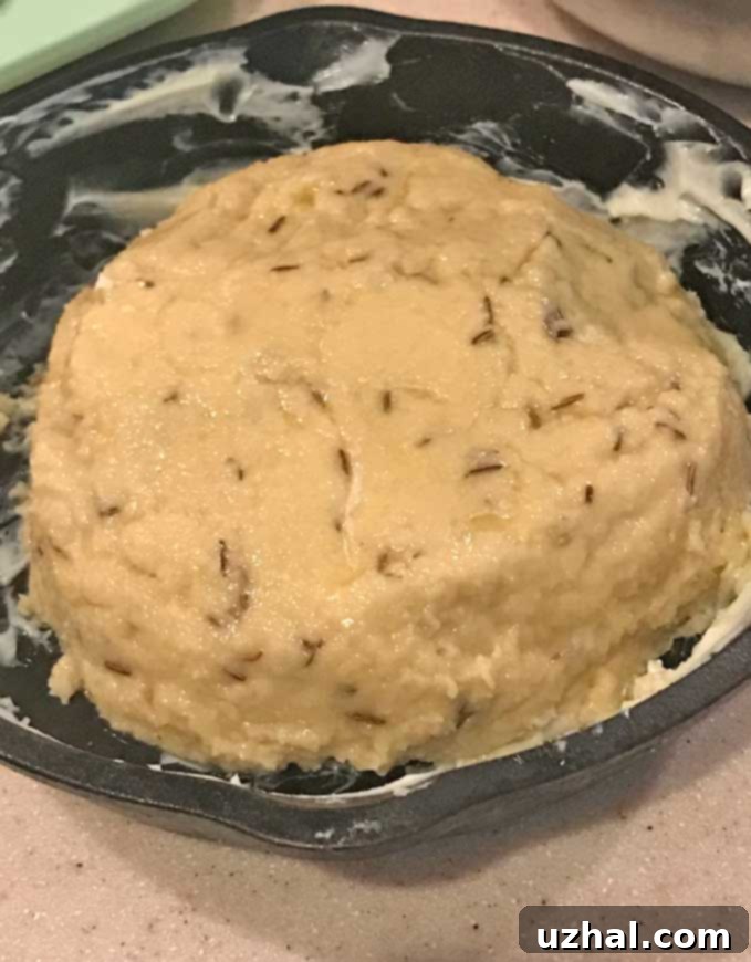 Gluten-Free Almond Meal Irish Soda Bread dough with visible caraway seeds in a mixing bowl.