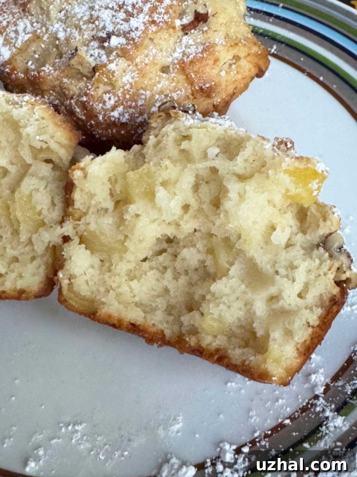 Yogurt muffin split open to show its moist and tender crumb texture with pineapple pieces