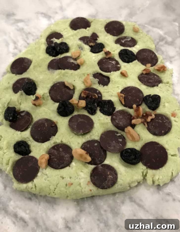 Green scone dough for Pistachio Pudding Mix Scones, pressed into a slab with Guittard chocolate wafers layered in.