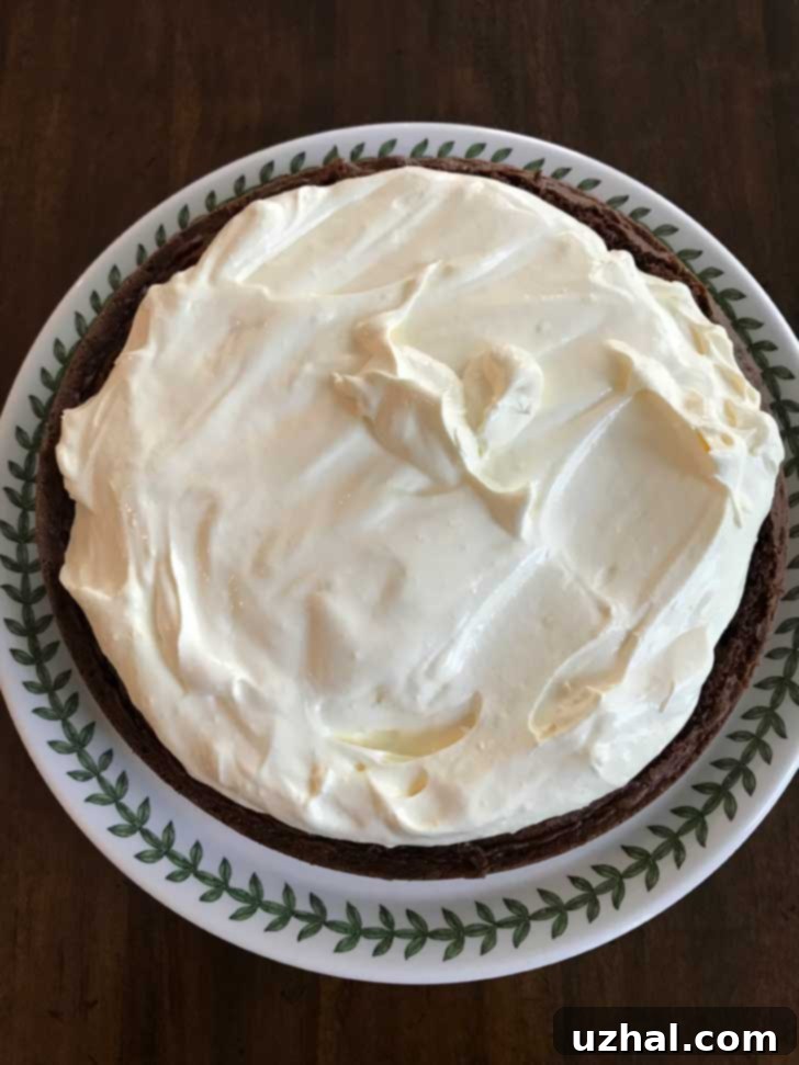 Smooth Bavarian Cream Filling spread over the first layer of a chocolate cake, ready for assembly.