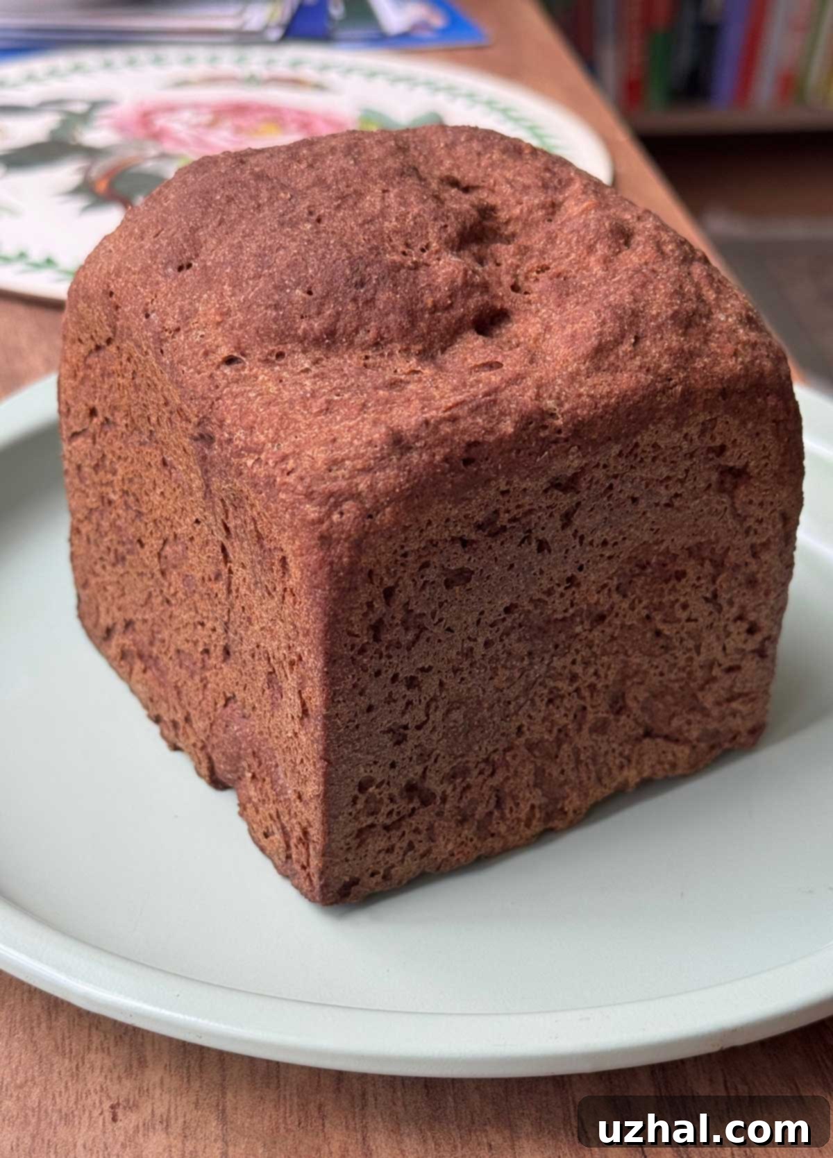 A small, cube-shaped loaf of gluten-free whole grain bread baked in a mini Pullman pan.