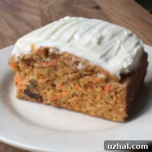 A close-up of a slice of the Cooking Light Carrot Cake with a thick layer of cream cheese frosting.