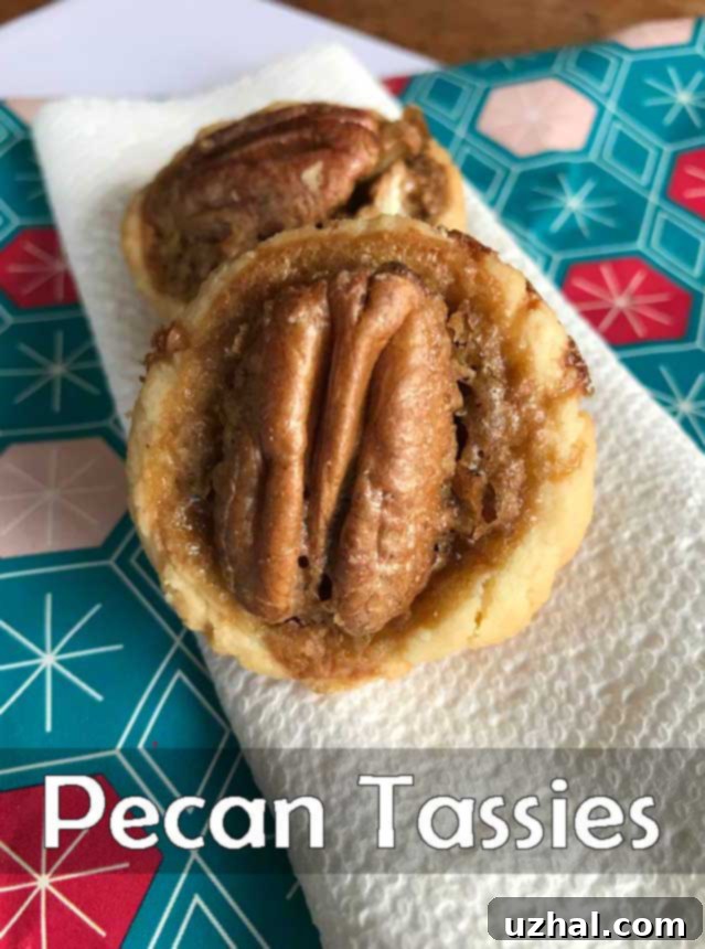 Freshly baked Pecan Tassies, golden brown and glistening with pecan halves on top