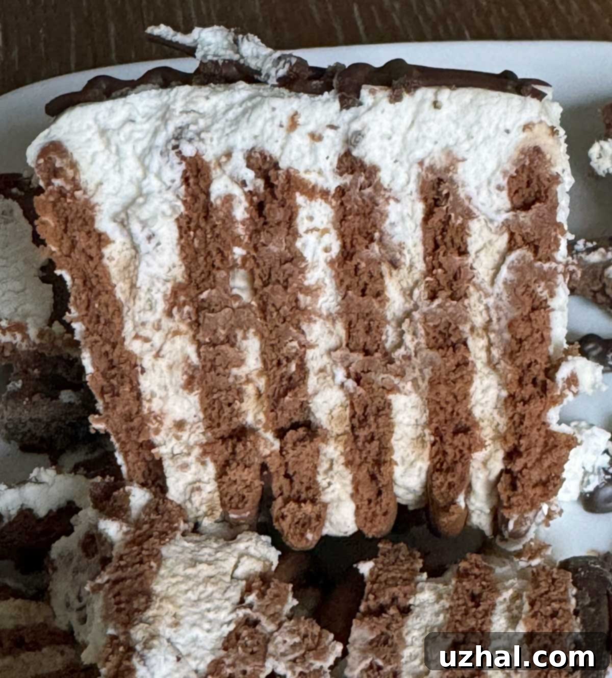 Close-up of a slice of Maria Cookie Icebox Cake with whipped cream