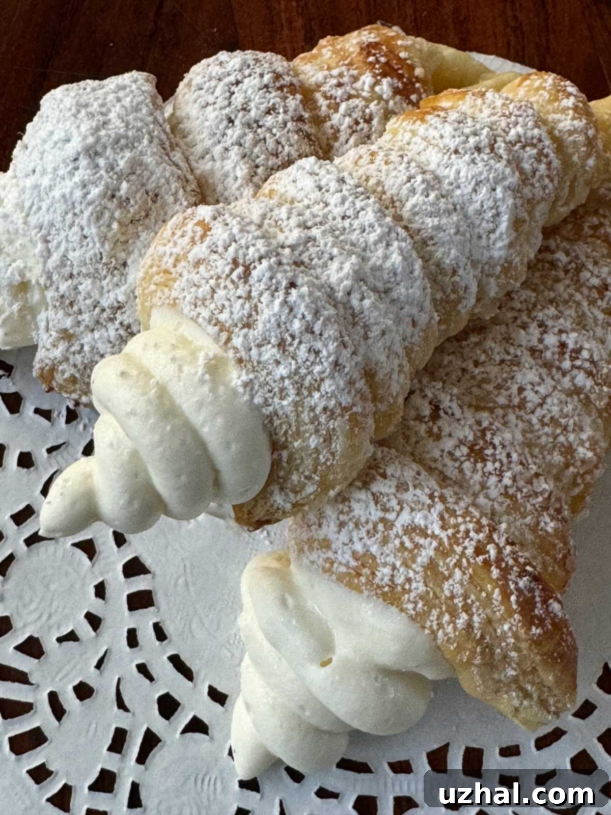 Easy Puff Pastry Cream Horns with a whipped white chocolate ganache, dusted with powdered sugar