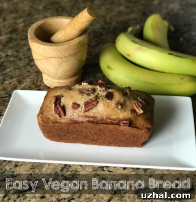 A small loaf of Vegan Banana Bread made with either all-purpose or gluten-free flour, sliced and ready to serve.
