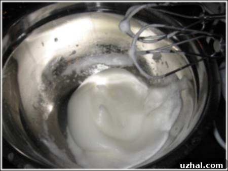 egg whites whipping in a metal bowl