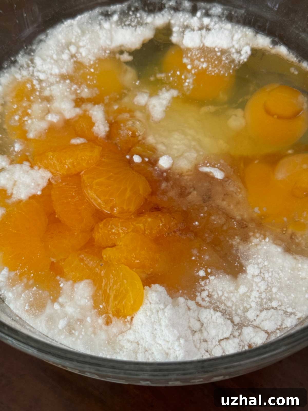 Pig Pickin' Cake Batter being mixed, showing the flecks of mandarin oranges throughout.