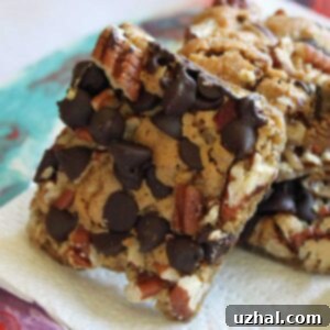 A golden-brown Texas Cookie bar, cut into a square, with visible pecans and melted chocolate chips. This image represents the recipe result.