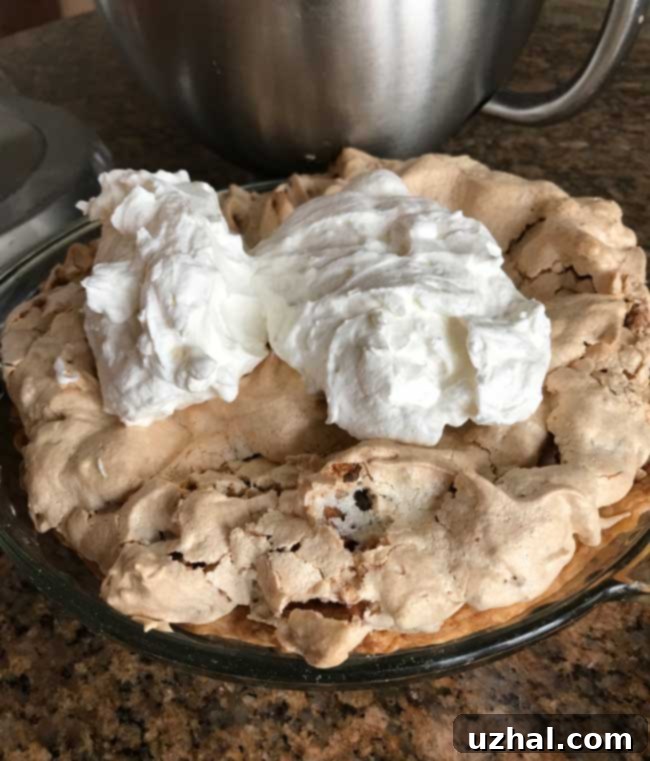Butternut Brownie Pie being topped with sweet whipped cream