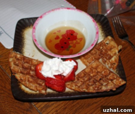 A close-up of several golden-brown, crispy yeasted waffles stacked neatly.