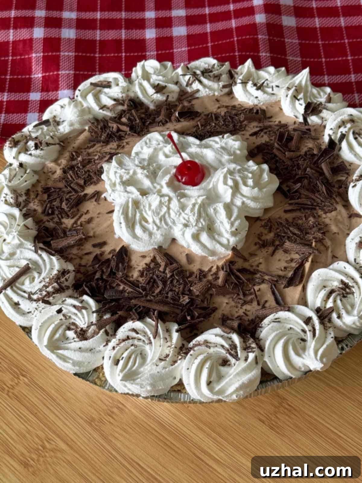 A beautifully decorated layered chocolate cream pie, garnished with whipped cream rosettes and chocolate shavings, specifically prepared for New Year's Eve festivities.