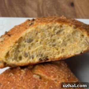 Loaf of Pumpkin Seed Bread with cornmeal sliced to show texture.