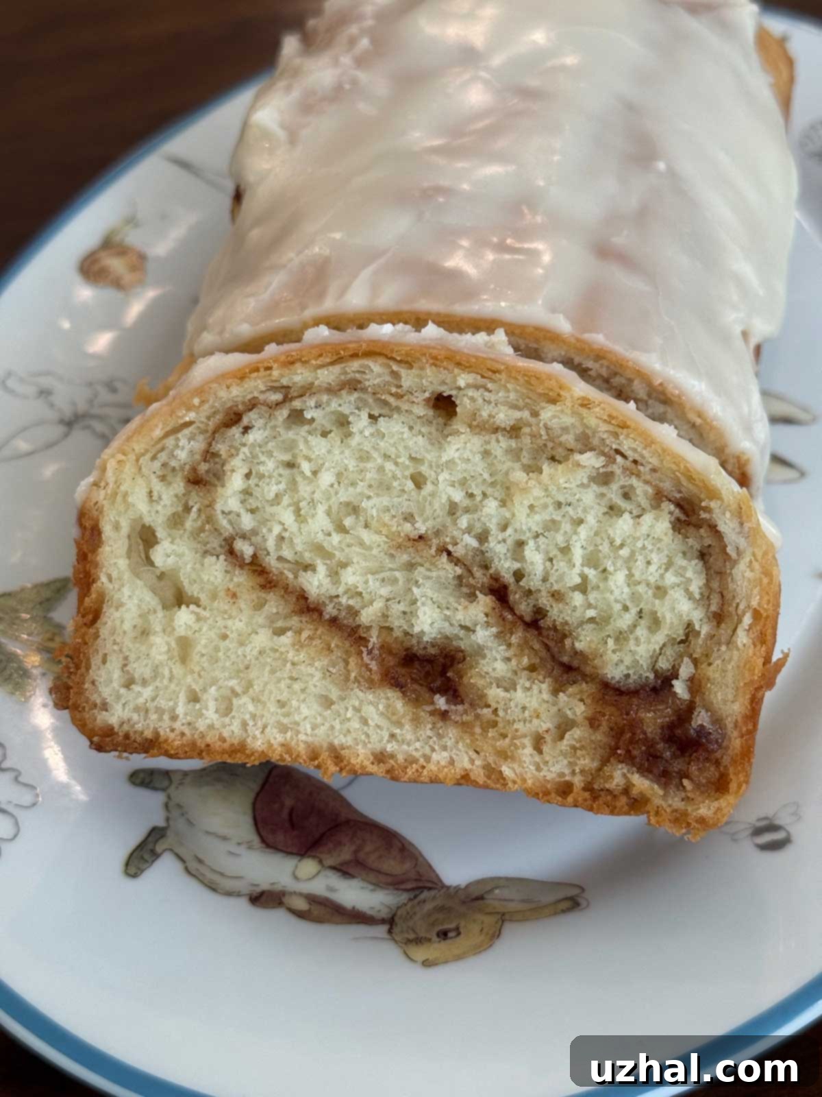 Two golden-brown cinnamon swirl loaves, freshly baked and ready to be sliced, showcasing a beautiful swirl pattern inside.