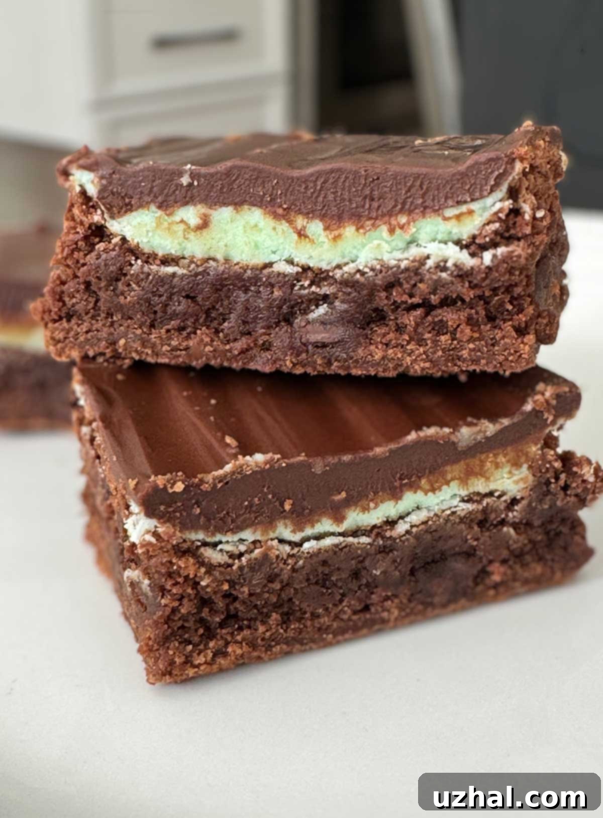 Fudgy Chocolate Mint Buttercream Brownies layered with green mint frosting and a shiny dark chocolate topping