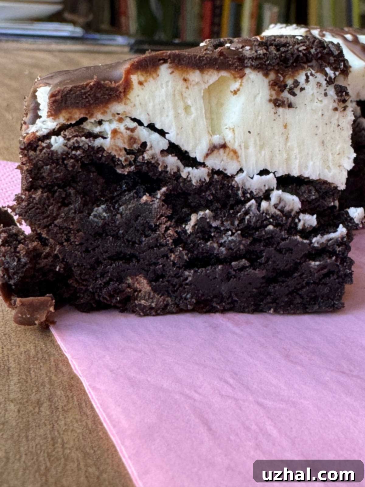 Side view of a Crumbl Oreo Brownie, displaying its thick layers of brownie and frosting.