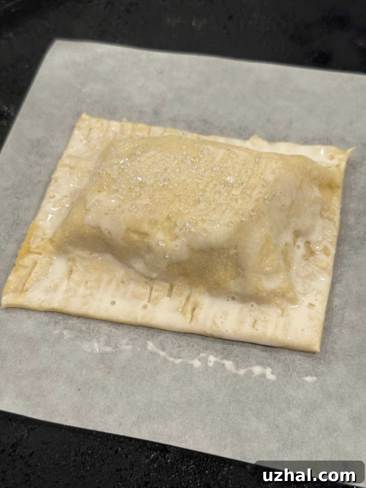 Golden Sweet Apple Pockets 4 An unbaked apple hand pie brushed with cream, ready for baking.