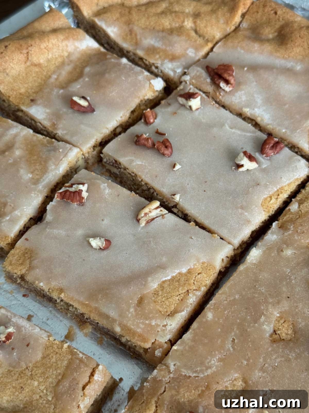 Brown Butter Maple Pecan Blondie Bars 2 Close-up of golden brown butter maple toasted pecan sheet pan cookies, showcasing their chewy texture and pecan pieces.